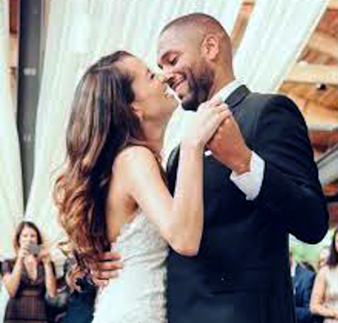A bride and groom smiling forehead to forehead during their first dance