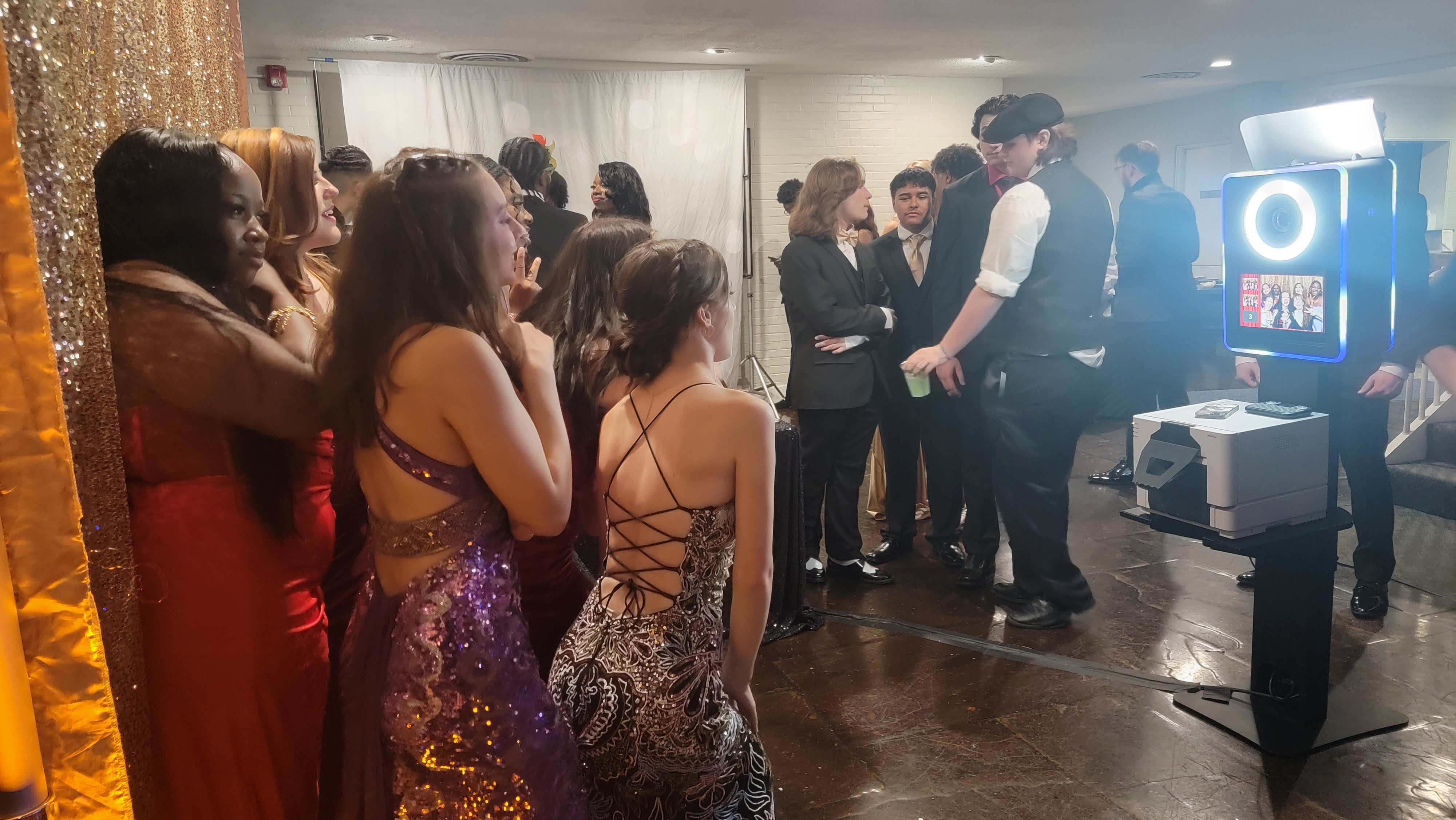 Students in prom dresses waiting their turn at the open-air photo booth