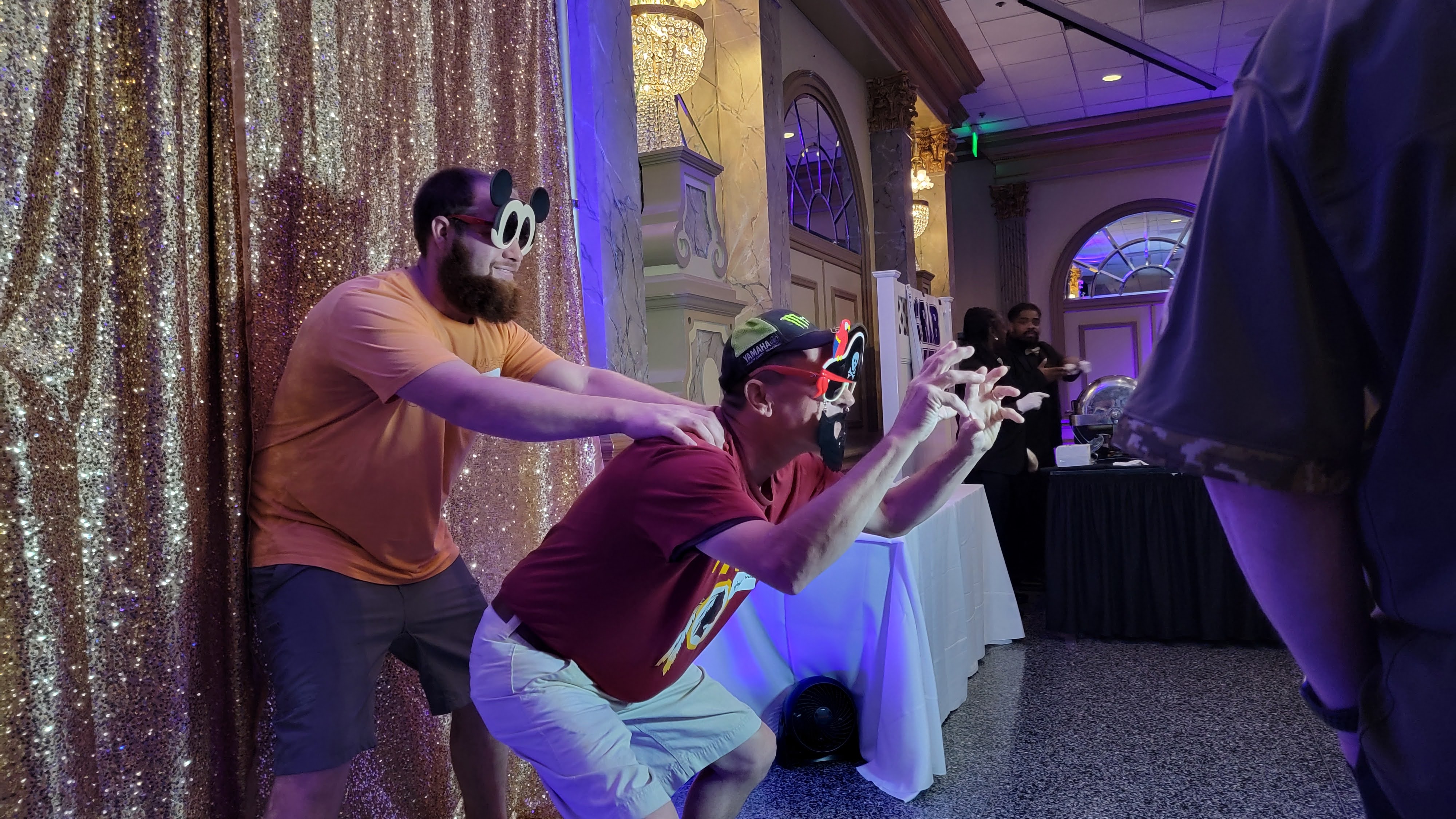 Two guests in Mickey ears and pirate glasses striking a pose at the booth