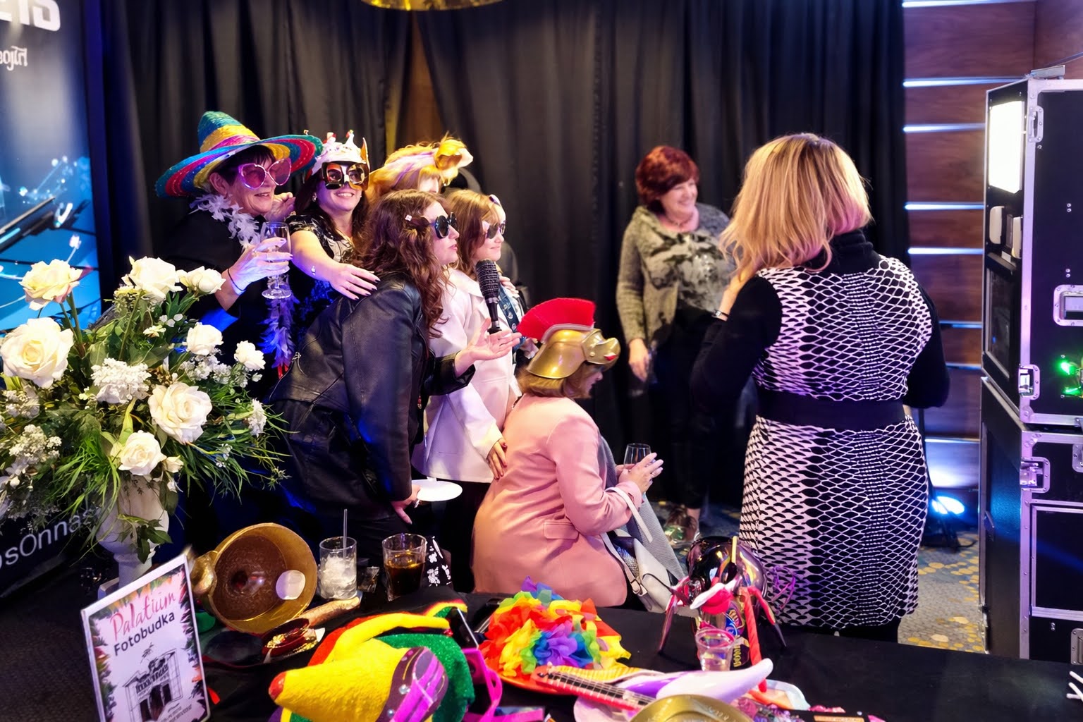 Guests in sombreros, crowns and masks gathered around the photo booth prop table