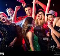 Group of friends in party hats dancing and cheering together under colorful lights at a dance party