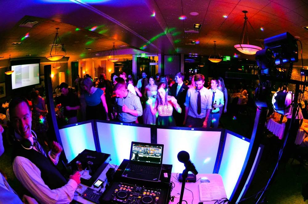 A MusicMasters DJ booth beside a busy dance floor