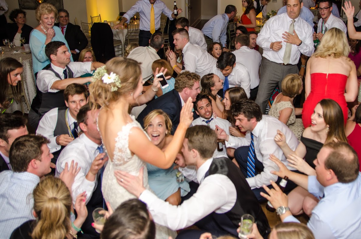 A bride surrounded by guests on the reception dance floor