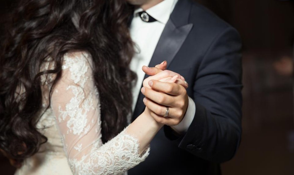 Bride and groom holding hands during their first dance
